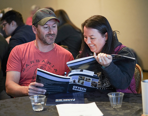 Man and woman sitting at table looking at books