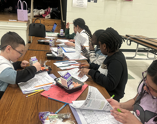 Group of kids at a table doing home at the YMCA